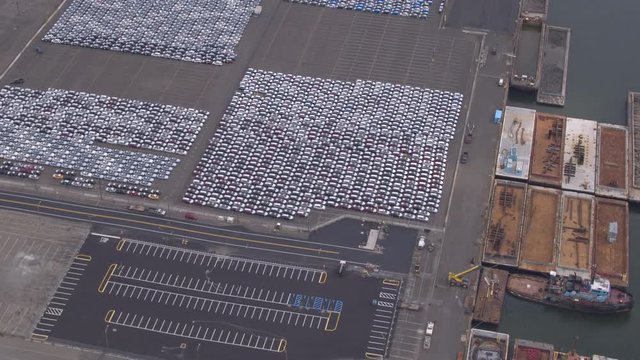 AERIAL: Vehicles on parking lot of worldwide automobile shipment logistic center