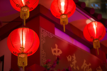 Multiple hanging red paper lantern as decoration for Chinese New Year celebration with a signboard...