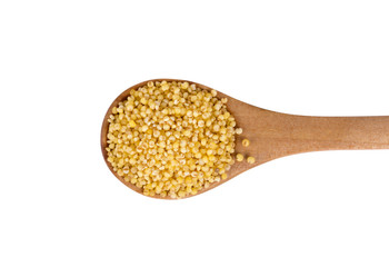 Yellow millet seeds on a wooden spoon