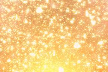 Golden  sparkles or glitter lights. Merry Christmas festive gold background.defocused circle bokeh or particles