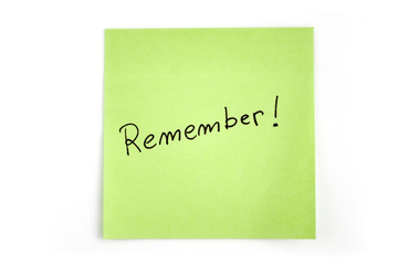 Green sticky note with "remember" word, isolated on white background. Picture taken in studio with soft-box.