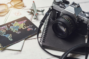 Retro camera and map on wooden table