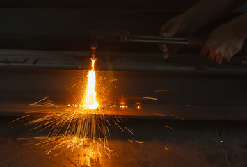Metal cutter, steel cutting with acetylene torch, industrial worker on manufacturing area.