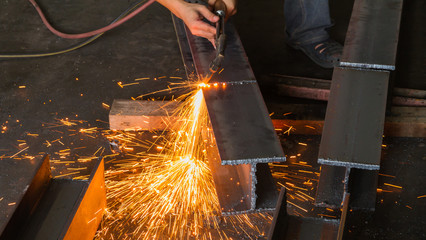 Metal cutter, steel cutting with acetylene torch, industrial worker on manufacturing area.