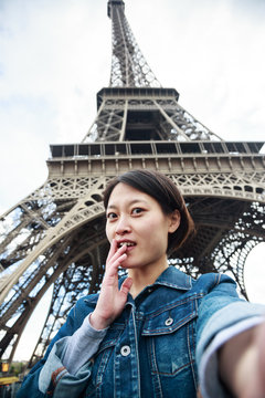 Young Chinese Female Tourist In Front Of The Eiffel Tower