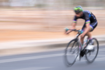 Blurred background of a man riding bicycle.