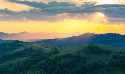 Mountain range in sunset light rays through the hole in clouds. Carpathian mountains. Ukraine.