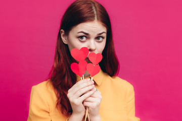 beautiful woman with red hearts on a stick, pink background