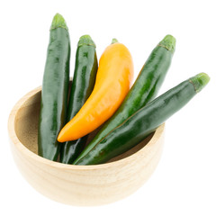 Green and yellow chili pepper in wooden cup isolated on white background.