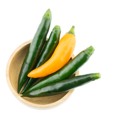 Green and yellow chili pepper in wooden cup isolated on white ba