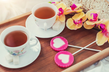 Obraz na płótnie Canvas Breakfast in bed in Valentines day. Cup of tea and sweet candies. Love or holiday concept