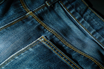 Back pocket of a blue jeans in the darkness