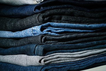 Lots of jeans stacked in the darkness