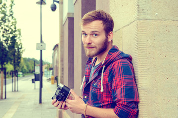 young bearded man with old camera