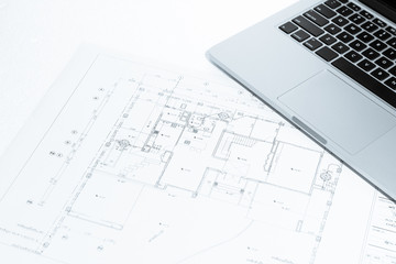 notebook over house construction blueprint with blue tone effect
