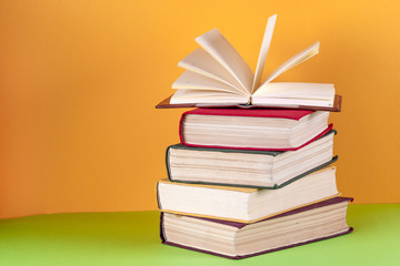 Open book, hardback bookson bright colorful background.