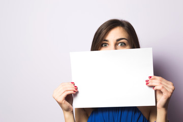 Portrait of a beautiful girl with a sheet of paper in his hands