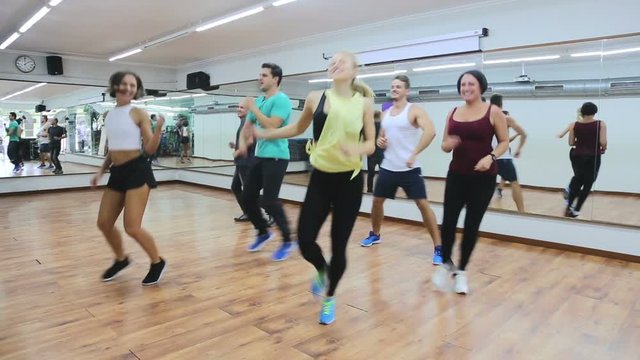

Smiling men and ladies dancing zumba at lesson
