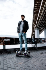 trendy guy standing on a gyro scooter