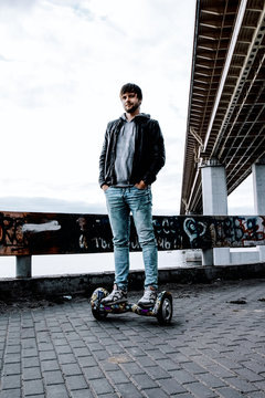 trendy guy standing on a gyro scooter