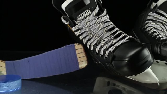 Close-up dolly shot on hockey skates , puck and stick.