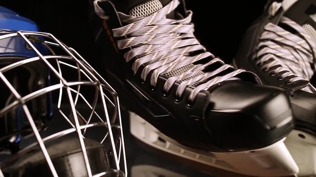 Close-up dolly shot on hockey skates and hockey helmet.