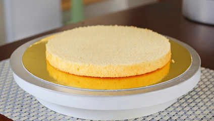 Cake in process on stand on wooden table, Homemade Cake.