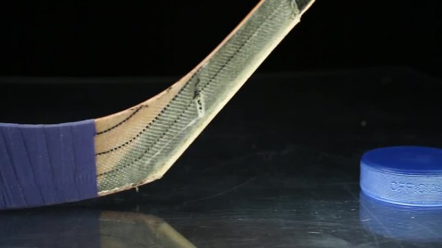 Close-up dolly shot on hockey stick and hockey puck.