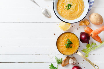 Roasted pumpkin and carrot soup on white wooden background. Copy space. Vegetarian concept
