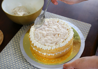 Cake in process on stand on wooden table, Homemade Cake.