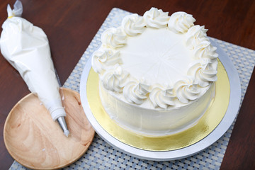Cake in process on stand on wooden table, Homemade Cake.