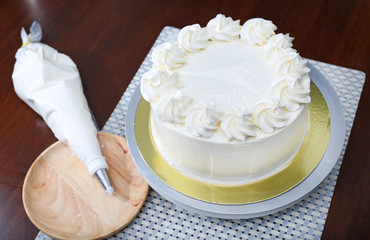 Cake in process on stand on wooden table, Homemade Cake.