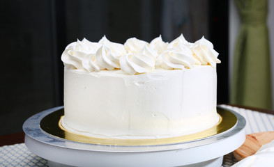Cake in process on stand on wooden table, Homemade Cake.