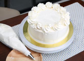 Cake in process on stand on wooden table, Homemade Cake.