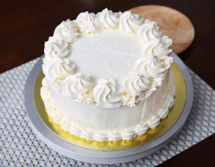 Cake in process on stand on wooden table, Homemade Cake.