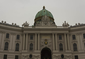 Fototapeta na wymiar Architectural detail of the imperial facade of Hofburg Palace in Vienna, with its green dome
