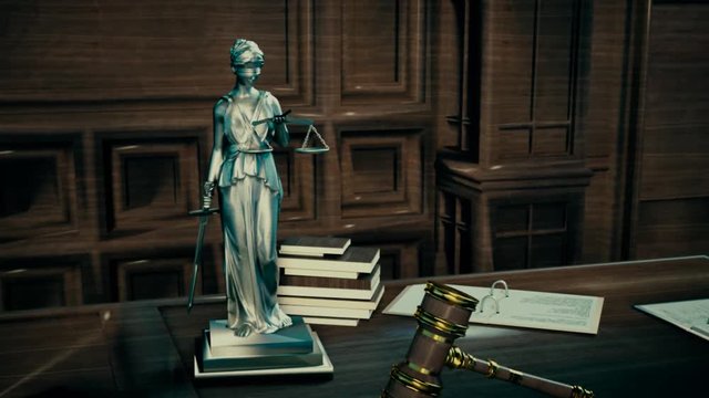 the attributes of the court statue of justice and judge's gavel on the table
