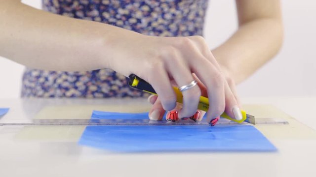 Shaping blue paper with knife and ruler 4K
