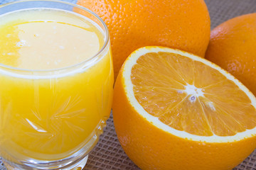 Orange juice in  glass and oranges
