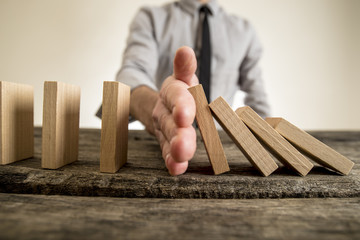 Businessman halting the domino effect