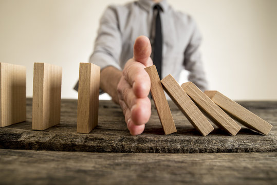Businessman halting the domino effect