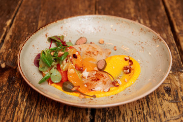 Seafood starter with orange slices and pumpkin mash