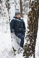 Portrait of cute boy in winter forest.