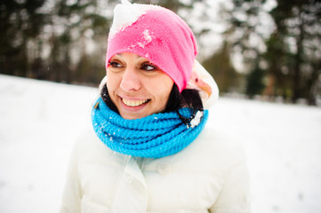 Charming young woman plays with someone in snowballs.