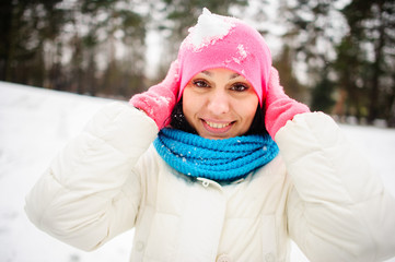 Charming young woman plays with someone in snowballs.