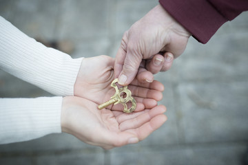 鍵を手渡す親子の手