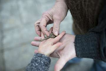 鍵を手渡すお婆さんと孫娘の手