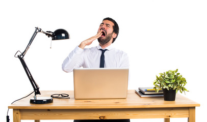 Businessman in his office yawning