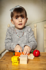 Mädchen kocht mit Holzspielzeug