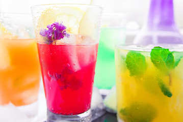 Different kinds of fresh lemonades in glasses on wooden background